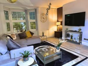 a living room with a couch and a tv at *Luxury 9ine Lush Jacuzzi Apartment & Balcony* in Birmingham