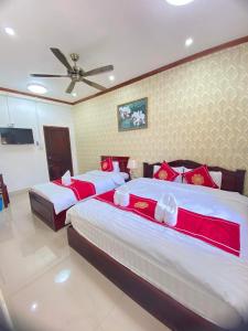 a bedroom with two beds and a ceiling fan at Xuan Keo place house 2 in Luang Prabang