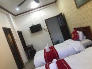 Pokój hotelowy z 2 łóżkami i lustrem w obiekcie Xuan Keo place house 2 w mieście Luang Prabang