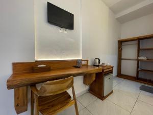Habitación con escritorio de madera y TV en la pared. en Balian Paradise Resort en Selemadeg