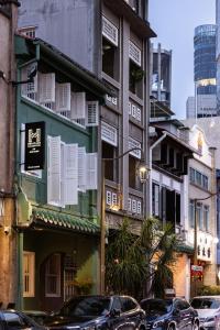 uma rua com carros estacionados em frente aos edifícios em NEWLY REFURBISHED - Heritage Collection on Ann Siang em Singapura