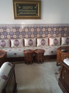 Marrakech plus في مراكش: غرفة معيشة مع أريكة وطاولات