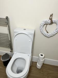 a bathroom with a toilet and a wreath on the wall at Motorpoint view in Nottingham