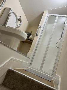 a bathroom with a glass shower door on the stairs at Motorpoint view in Nottingham