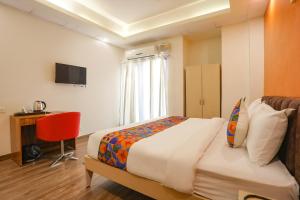 Dormitorio con cama, escritorio y TV en FabHotel Spark Inn I, en Gurgaon