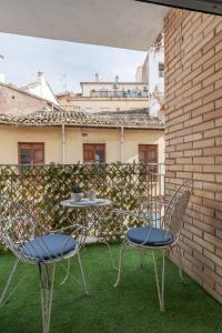 two chairs and a table on a patio at tuGuest Santa Paula III Apartment in Granada