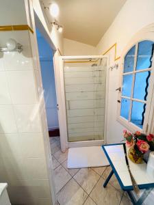 uma casa de banho com um chuveiro, uma mesa e uma cadeira em Chambre indépendante à Lezignan-la-Cèbe em Lézignan-la-Cèbe