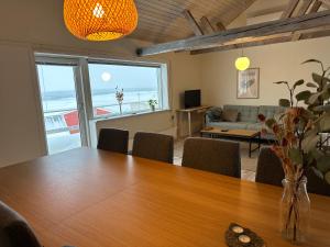 a dining room with a table and a living room at Grand seaview house Ilulissat in Ilulissat