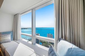 1 dormitorio con ventana grande con vistas al océano en Casiola Apartments in Four Seasons Miami, en Miami