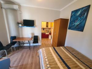 1 dormitorio con cama, mesa y cocina en My Apartments Durres, en Durrës