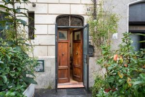 an open wooden door in a building with plants at DOMUS GELSOMINO in Rome