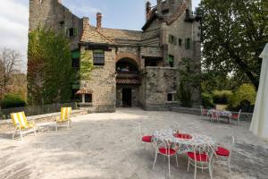 une table et des chaises en face d'un château dans l'établissement Villa Rocchetta, à Bosisio Parini