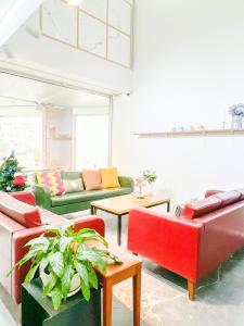 a living room with red and green couches at Empathy Guesthouse in Daegu