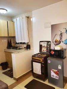 a small kitchen with a stove and a refrigerator at macdade apartment in Nairobi