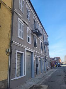 a gray building with a garage on a street at Appartamento Reale in Alessandria