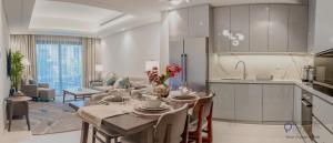 フジャイラにあるCapital Stay - 2 Bed Apartment- The Address Fujairahのキッチン、リビングルーム(テーブル付)が備わります。