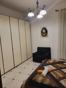 - une chambre avec un lit et une chaise dans l'établissement Appartamento Reale, à Alexandrie