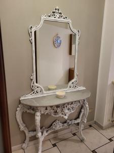 a white dressing table with a mirror on it at Appartamento Reale in Alessandria