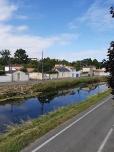 una carretera junto a un río con casas en Niort au bord de l'eau 3, en Niort