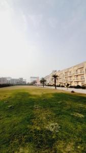 a large field of grass with buildings in the background at Amber suits and Hotal in Vrindāvan