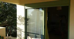 una puerta corredera de cristal de una casa con ventana en Wave Sound - summer apartment en Kakóvatos