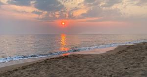 una puesta de sol en una playa con el océano en Wave Sound - summer apartment en Kakóvatos