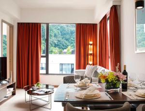 una sala de estar con mesa de comedor y una sala de estar con cortinas rojas. en Eaton Residences, Blue Pool Road en Hong Kong