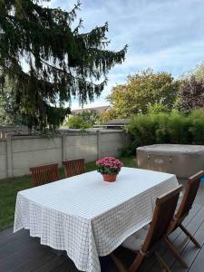 einen Tisch mit einer Blumenvase auf einer Terrasse in der Unterkunft Maison moderne à 25 minutes du centre Paris et JO 2024 in Eaubonne