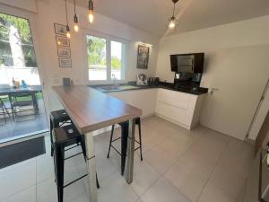 a kitchen with a wooden table and a microwave at Maison moderne à 25 minutes du centre Paris et JO 2024 in Eaubonne