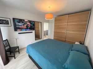 Schlafzimmer mit einem Bett und einem Flachbild-TV in der Unterkunft Maison moderne à 25 minutes du centre Paris et JO 2024 in Eaubonne