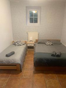 two beds in a room with a window at Central and affordable room in basement in Krakow