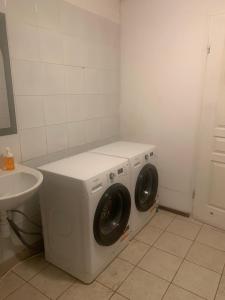 a washing machine in a bathroom with a sink at Central and affordable room in basement in Krakow