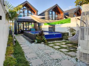 a house with a pool and a hammock in the yard at Hidden Haven Subic Villa w/ Infinity Pool in Subic