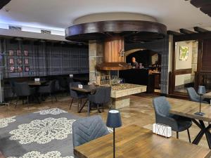 a restaurant with tables and chairs and a man in the mirror at Hotel FaMil - adults only in Bansko