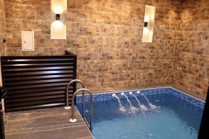 a hot tub in a room with a brick wall at نيلوفر بيتي in Sūq al Aḩad