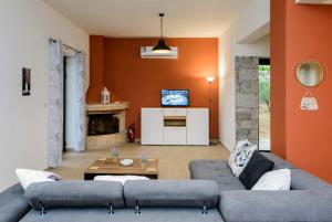 a living room with two couches and a tv at Mani's Best Kept Secret - Seaview Villa Lida in Agios Nikolaos