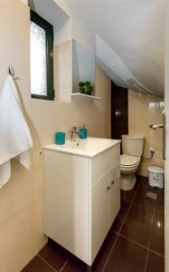 a bathroom with a sink and a toilet at Mani's Best Kept Secret - Seaview Villa Lida in Agios Nikolaos