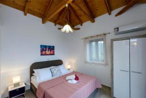 a bedroom with a bed with a pink blanket at Mani's Best Kept Secret - Seaview Villa Lida in Agios Nikolaos