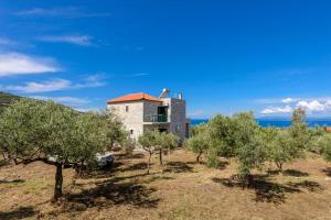 a house in the middle of a field with trees at Mani's Best Kept Secret - Seaview Villa Lida in Agios Nikolaos