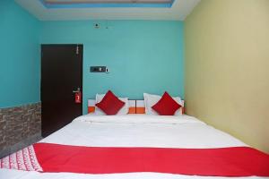 a bedroom with a large bed with red pillows at Hotel continental in kolkata