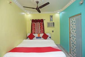 a bedroom with a bed with a ceiling fan at Hotel continental in kolkata