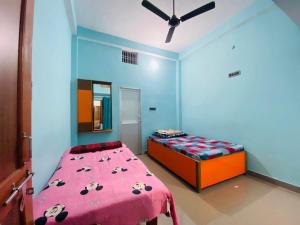 a bedroom with a bed with a pink blanket at The Narayan Bhawan , ramanuj ashram ,haridas nagar ,ramkot ayodhya ji in Ayodhya