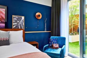 アントワープにあるホテル インディゴ アントワープ シティセンターの青い壁のベッドルーム1室(ベッド1台付)