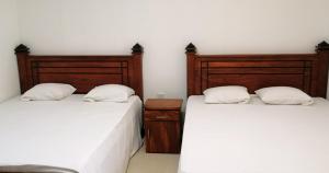 2 Betten nebeneinander in einem Zimmer in der Unterkunft Geeth Lanka River Resort in Matale