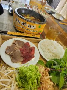 una mesa con un plato de comida y un tazón de sopa en Khách sạn Hậu Giang, en Vị Thanh