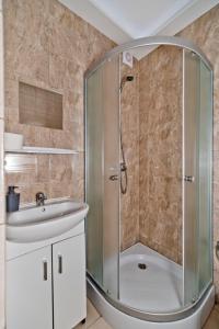 La salle de bains est pourvue d'une douche et d'un lavabo. dans l'établissement Resort EDEN - domki, pokoje, apartamenty, à Jastrzębia Góra