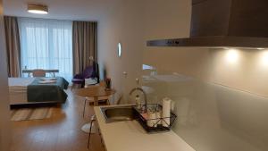 uma cozinha com um lavatório e um quarto com uma cama em Kazimierz Center Apartments Halicka em Cracóvia