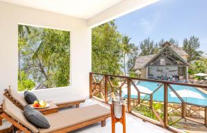 a room with a balcony with a view of the ocean at Zanzibella Hotel & SPA in Kiwengwa