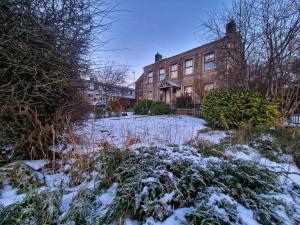 a house with snow on the ground in front of it at the lodge@ beechwood house in Mossley