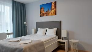 um quarto com uma cama com uma fotografia na parede em Kazimierz Center Apartments Halicka em Cracóvia